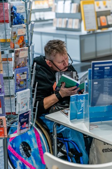 Lesender Besucher im Rollstuhl auf der Buch Wien 23